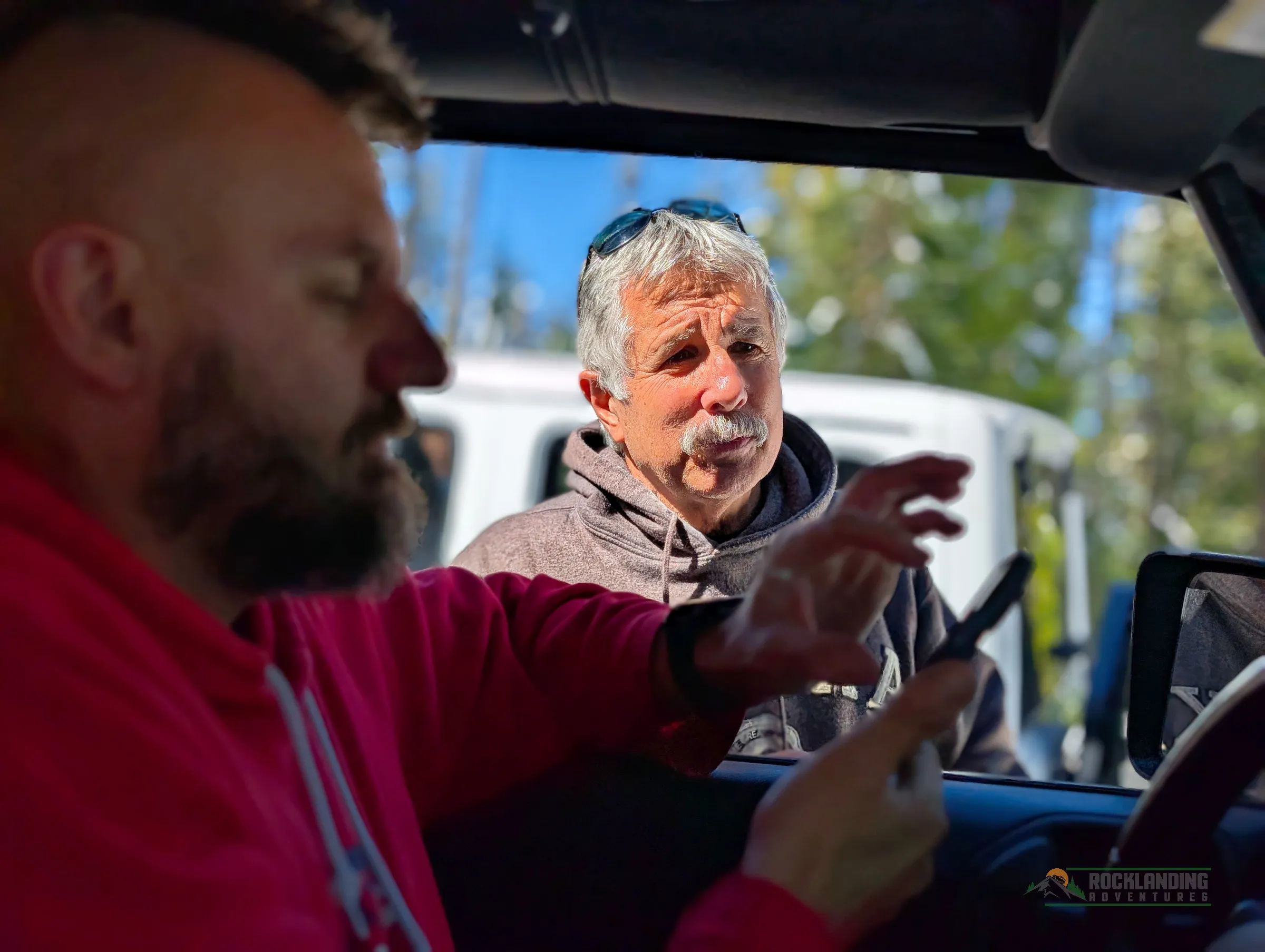 Two people watching a phone, and deciding on the next steps